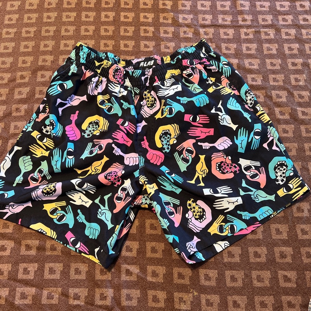 Black swim trunks with colorful hand print.